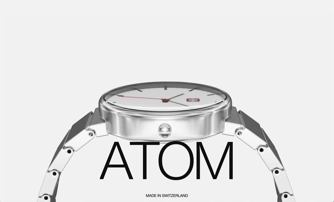 A sleek silver wristwatch with "ATOM" text and "Made in Switzerland" label.